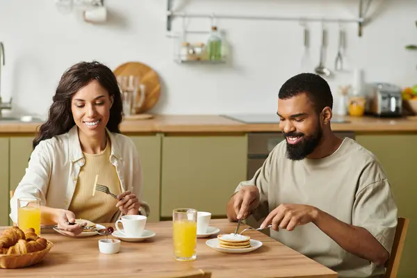 A joyful couple enjoys a delightful breakfast together, savoring each others company and food. — Stock Photo