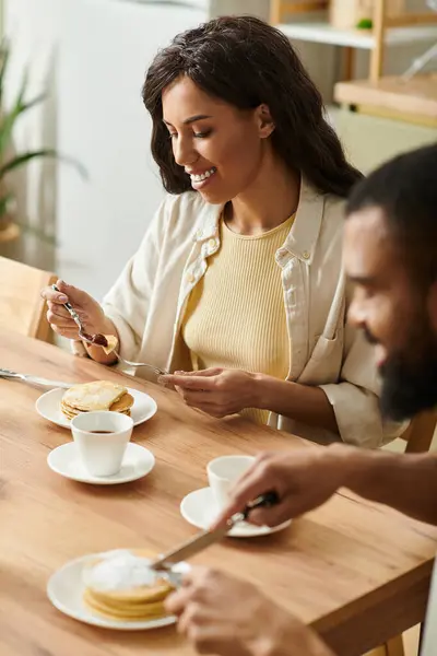 Couple enjoying a delightful breakfast at home with pancakes and coffee, radiating warmth and love. — Stock Photo