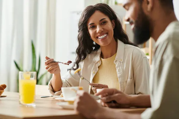 Um casal negro alegre desfruta de um delicioso café da manhã em casa, saboreando seu tempo juntos. — Fotografia de Stock