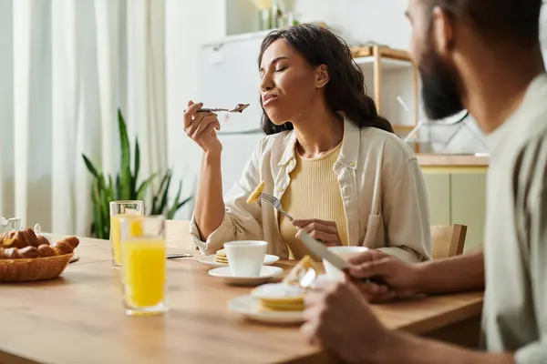 A loving couple enjoys a delightful meal together at their cozy home, savoring each moment. — Stock Photo