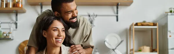 Loving couple shares a warm, intimate moment in their kitchen, reflecting happiness and connection. — Stock Photo