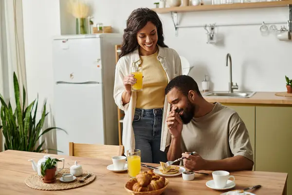 A cozy Black couple enjoys a loving breakfast, smiles lighting up their morning. — Stock Photo