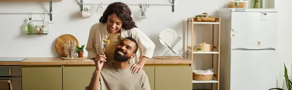 A loving couple shares playful moments in their cozy kitchen, celebrating togetherness. — Stock Photo