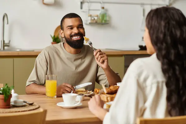 A man and woman enjoy a joyful breakfast together in their cozy home. — Stock Photo