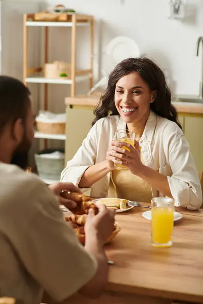 A couple enjoys breakfast together, sharing smiles and laughter in their warm and inviting home. — Stock Photo
