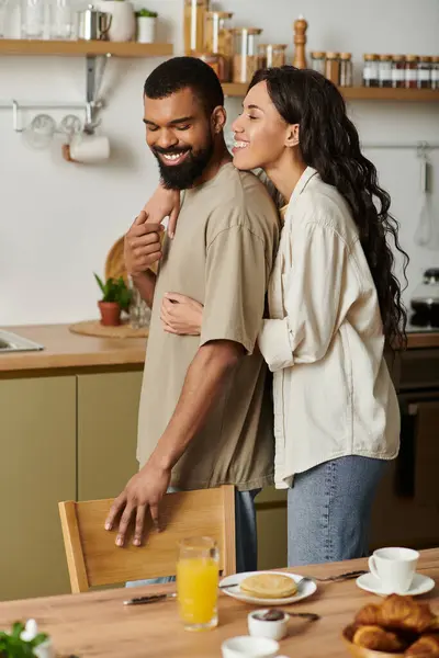 A loving couple enjoys a joyful morning together in their cozy kitchen, making memories. — Stock Photo