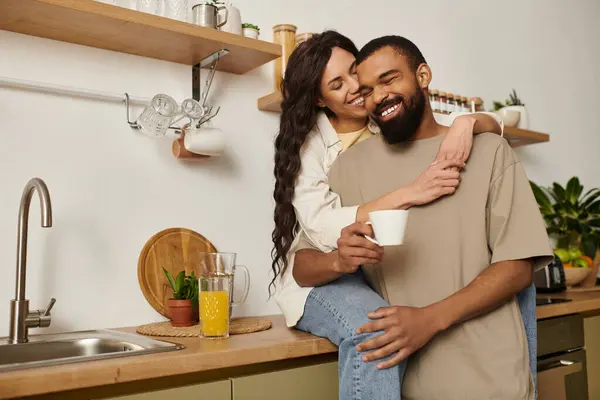 A couple enjoys intimate moments together in their kitchen, sharing love and joy over drinks. — Stock Photo