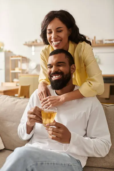 A joyful couple enjoys a peaceful evening together at home, laughing and sharing warm tea. — Stock Photo