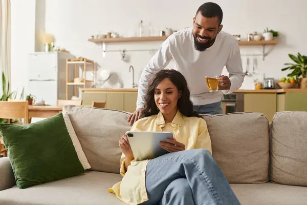 A joyful African American couple laughs together in their cozy living room, showcasing their bond. — Stock Photo
