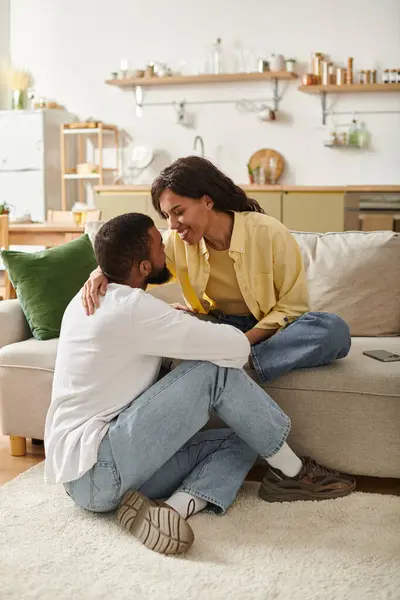 A nurturing moment unfolds as a loving couple shares smiles and closeness in their warm home. — Stock Photo