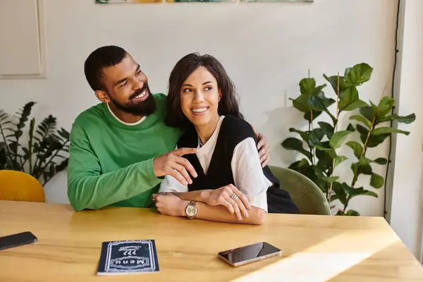 An African American couple shares laughter and warmth while sitting at a cafe table. — Stock Photo