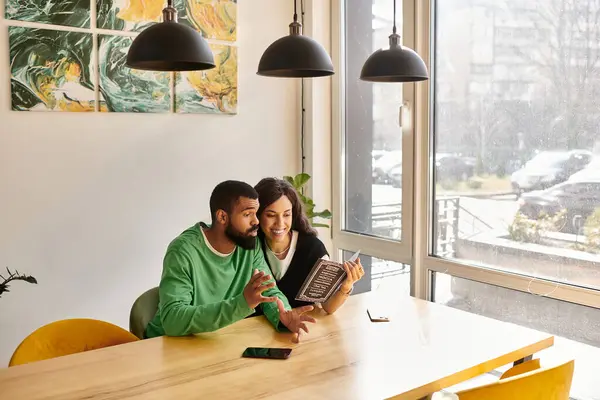 An African American couple shares laughter and joy while reading a menu in a lively cafe. — Stock Photo