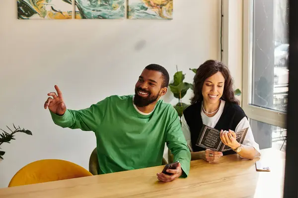 An African American couple shares laughs and drinks at a sunny cafe while reading the menu. — Stock Photo