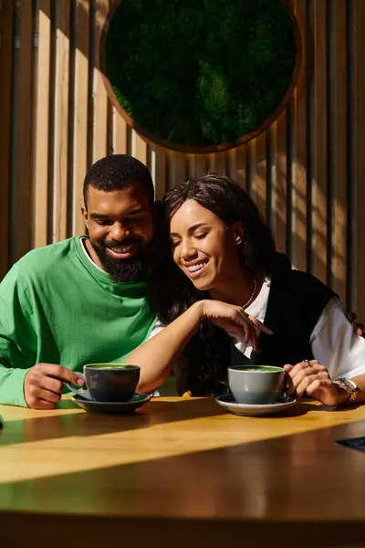 An African American couple shares laughter and warmth over coffee in a charming cafe setting. — Stock Photo