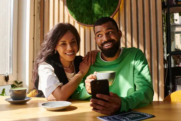 An African American couple enjoys beverages, smiling and sharing a light-hearted moment in a cafe. — Stock Photo