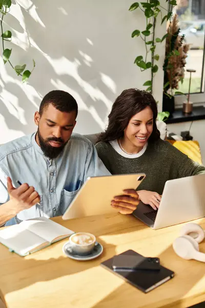 An African American couple enjoys working remotely together at a cafe while sharing ideas. — Stock Photo