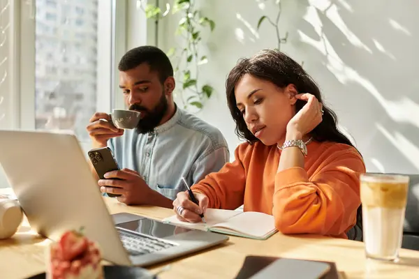 Couple engages in remote work at a lively cafe, exchanging ideas and enjoying coffee together. — Stock Photo