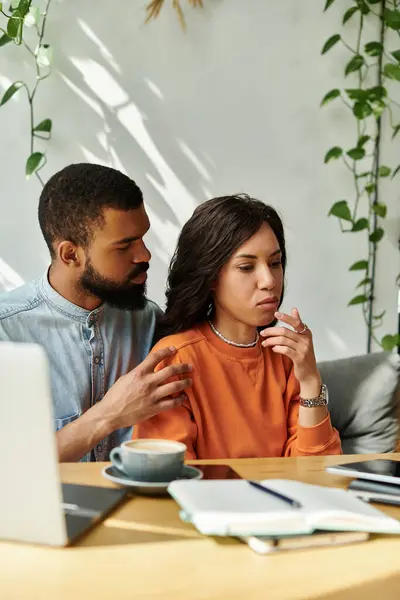 An African American couple engages in freelance tasks while enjoying a cafe atmosphere. — Stock Photo