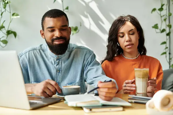 Dos profesionales disfrutan del café y se centran en las tareas de trabajo en un ambiente acogedor café. - foto de stock