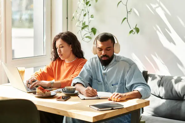 Casal afro-americano colabora em projetos freelance enquanto desfruta de confortos com café. — Fotografia de Stock