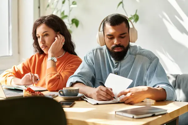 Este casal afro-americano está focado em seu trabalho freelance em um café acolhedor, compartilhando ideias. — Fotografia de Stock