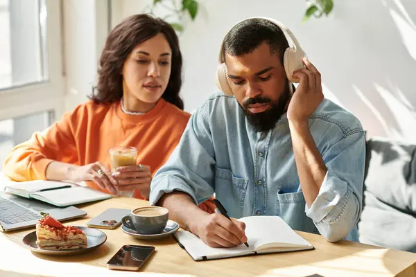 Um casal afro-americano colabora em projetos freelance em um café acolhedor, alimentado pela criatividade. — Fotografia de Stock