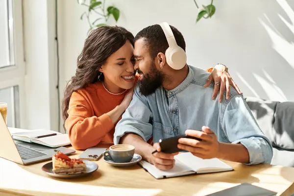 Dois indivíduos colaboram e compartilham momentos de alegria enquanto freelancer em um café pitoresco. — Fotografia de Stock