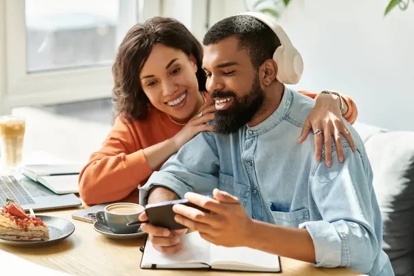 Um casal afro-americano gosta de trabalhar remotamente em um café acolhedor, compartilhando risos e amor. — Fotografia de Stock