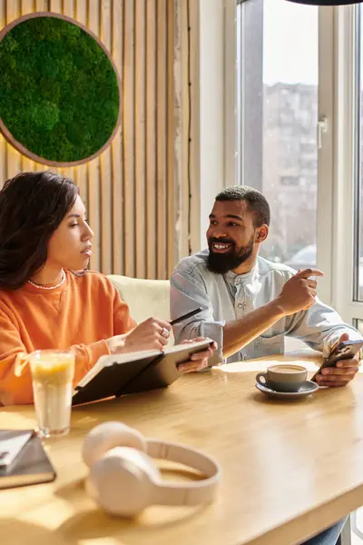 Una pareja disfruta de tiempo de calidad juntos mientras toman bebidas en un ambiente cálido café. - foto de stock