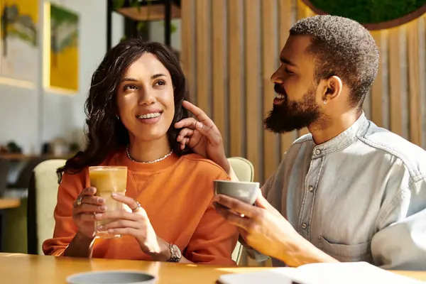 An African American couple enjoy quality time together, sharing drinks and laughter in a cafe. — Stock Photo