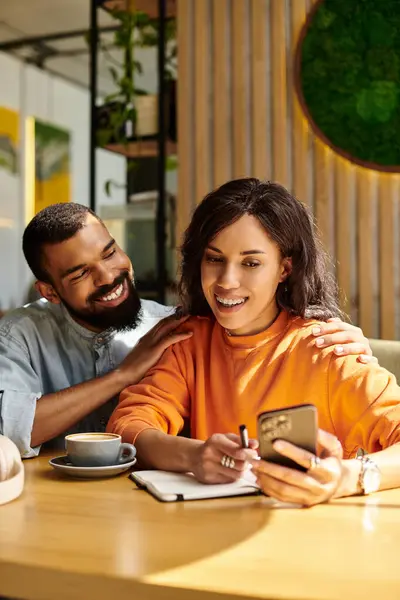 A couple enjoys their time together, laughing and sharing moments over coffee in a sunny cafe. — Stock Photo