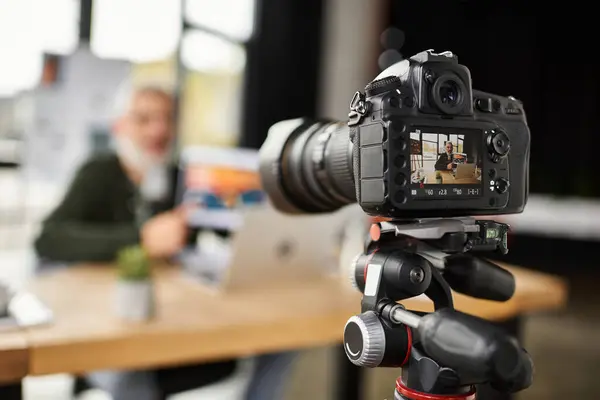 Una persona fa brainstorm in un ufficio mentre una telecamera registra il processo creativo. — Foto stock