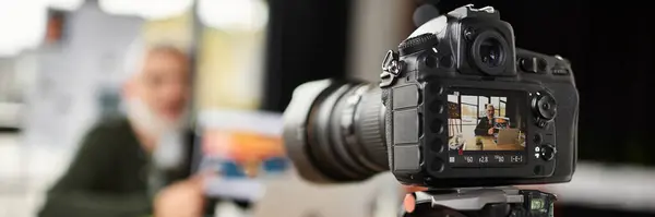 A professional camera focuses on capturing vibrant moments in a busy office environment. — Stock Photo