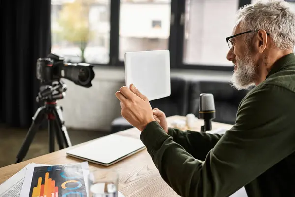 A person reviews presentation materials while preparing for a video discussion in a stylish office. — Stock Photo