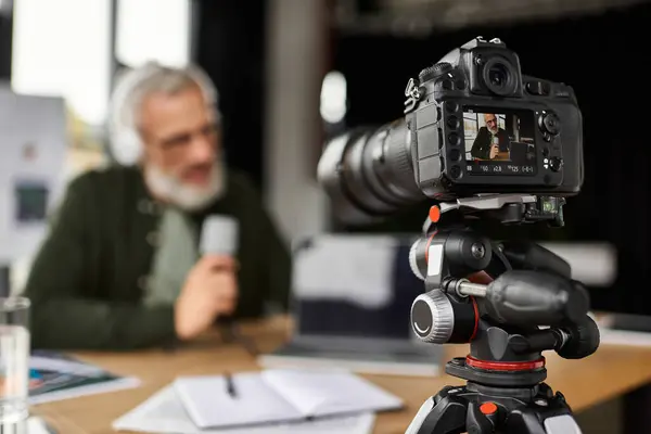 Expert shares insights on camera while being filmed in a lively, contemporary office setting. — Stock Photo