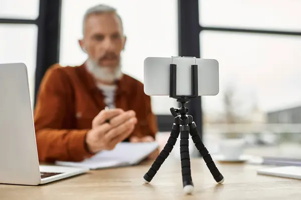 Un individuo focalizzato interagisce con la tecnologia, catturando idee in un ambiente di lavoro contemporaneo. — Foto stock