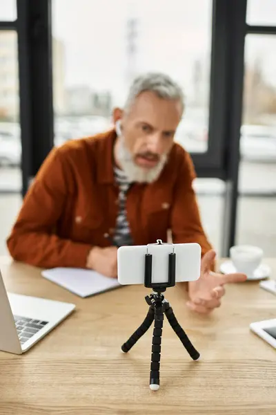 Un professionista senior è impegnato in una discussione animata durante un incontro virtuale in ufficio. — Foto stock
