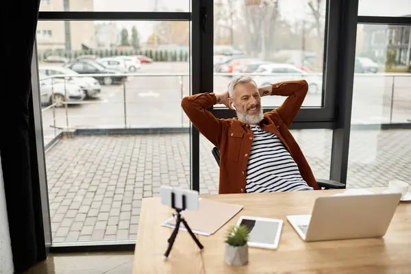 Ruhige Atmosphäre, die durch einen geräumigen Arbeitsplatz verstärkt wird, an dem ein Mann eine Pause am Schreibtisch genießt. — Stockfoto
