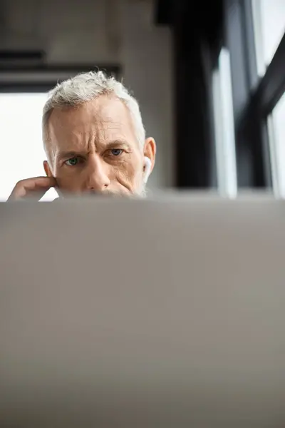 An individual attentively works on a computer, immersed in tasks within a contemporary office. — Stock Photo