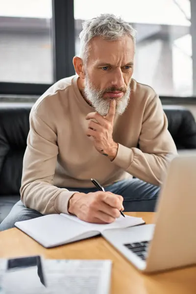 A focused person takes notes and analyzes info in a stylish office. — Stock Photo
