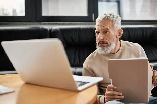 Una persona esamina le informazioni su un computer portatile, focalizzato e impegnato in un ufficio elegante. — Stock Photo