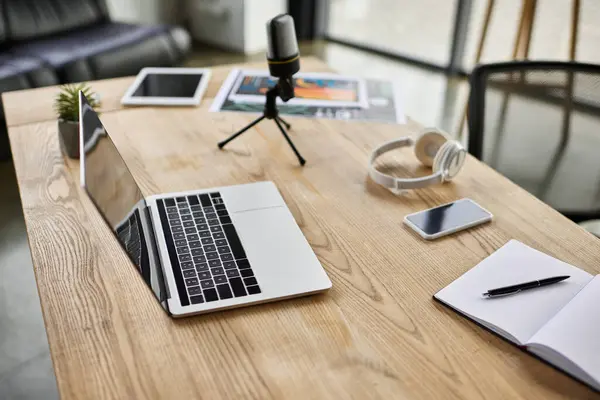 A chic desk with a laptop, headphones, and notepad inspires productivity in a modern workspace. — Stock Photo
