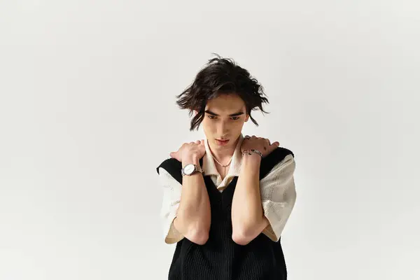 A handsome young man showcases a trendy outfit while striking a contemplative pose in the studio. — Stock Photo