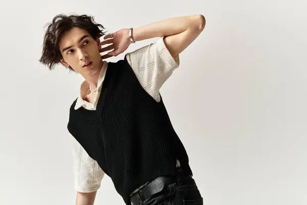 A confident young man poses effortlessly in a trendy outfit within a sleek studio environment. — Stock Photo