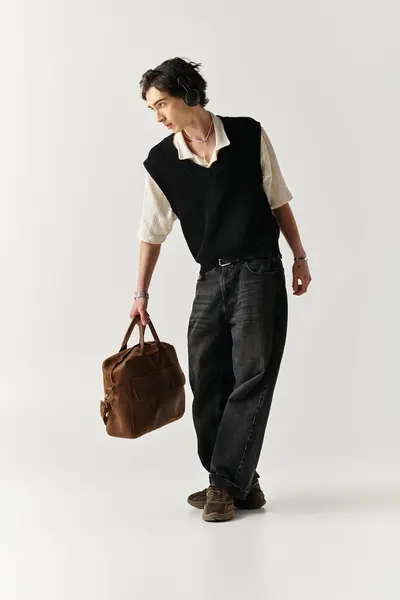 A handsome young man poses confidently in a trendy outfit within a sleek studio, exuding charm. — Stock Photo