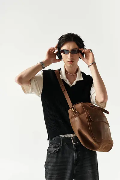 A handsome young man wearing a trendy outfit poses confidently in a well-lit studio. — Stock Photo