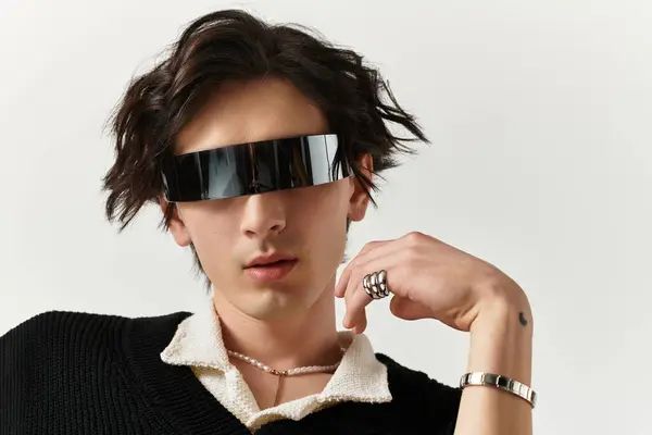 A handsome young man in an edgy outfit poses confidently in a contemporary studio space. — Stock Photo