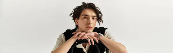 A handsome young man in a chic outfit poses confidently in a bright studio, expressing modern style, banner — Stock Photo