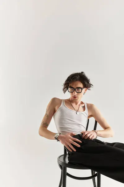 A slim young man poses confidently in a white tank top, embodying contemporary style and flair. — Stock Photo