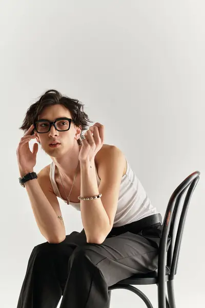 A fashionable young man in a white tank top poses stylishly, revealing modern trends and charisma. — Stock Photo